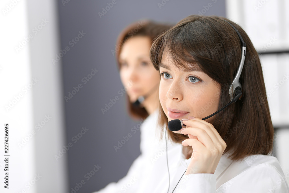 Call center. Group of operators at work. Focus on young brunette woman. Business concept Call center. Group of operators at work. Focus on young brunette woman. Business concept