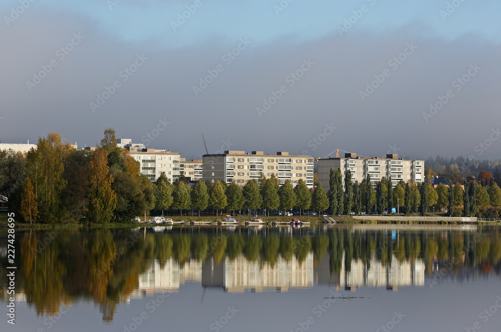 Naklejka premium Cityscape with white buildings and calm lake