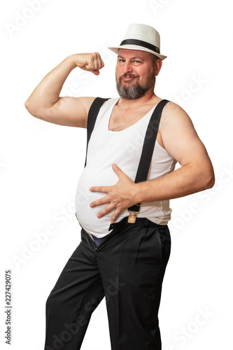 A brutal man with a hat and a T-shirt bent with one hand showing his strength, while the other holding his beer belly showing his weakness. photo