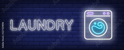 Laundry neon sign. Washing machine on brick background. Housework, chores, household equipment. Night bright advertisement. Vector illustration in neon style for hygiene, housekeeping, service  photo