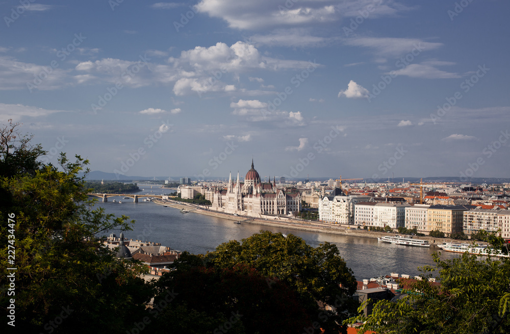 travel and european tourism concept. Budapest, Hungary. Hungarian Parliament Building over Danube River on sunny fay with blue sky.