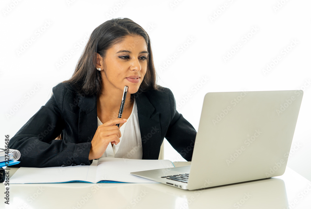Portrait of attractive young businesswoman working on her laptop looking happy and confident Portrait of attractive young businesswoman working on her laptop looking happy and confident