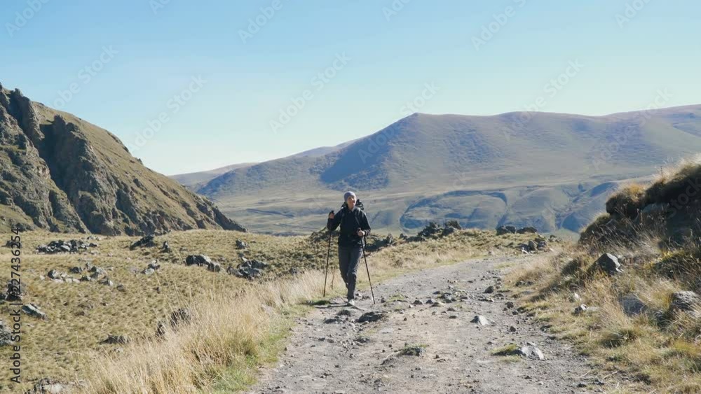 Hiker woman with backpack walking the edge of the canyon. Enjoying nature vacation travel adventure at Caucasus mountains. Hiker woman with backpack walking the edge of the canyon. Enjoying nature vacation travel adventure at Caucasus mountains.