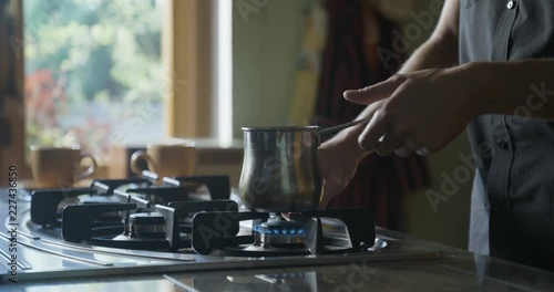 Man cooking coffee on a gas stove