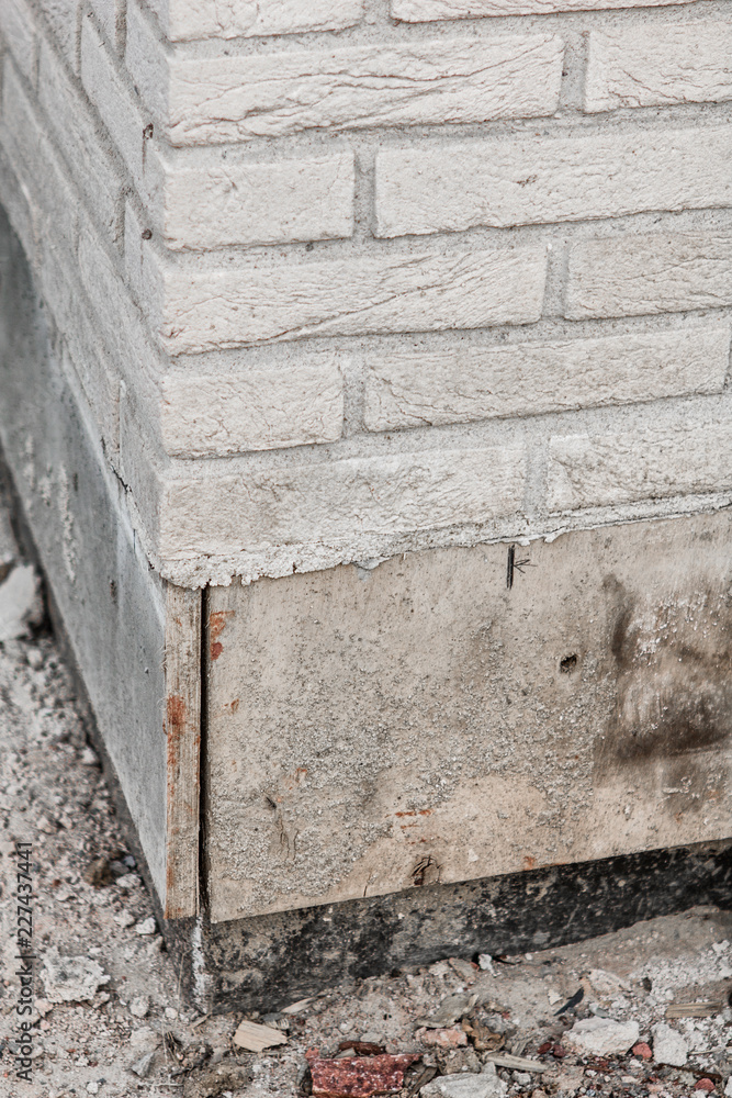 Corner of a white brick wall with part of the basement under construction Corner of a white brick wall with part of the basement under construction