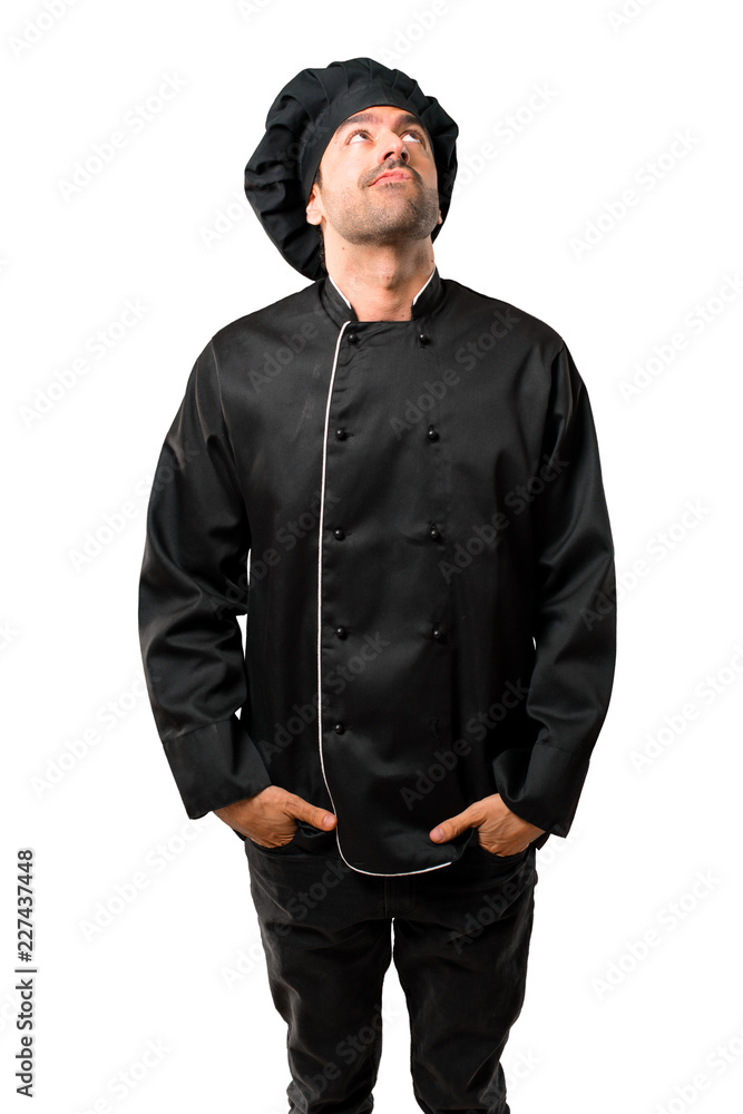 Chef man In black uniform stand and looking up with serious face on isolated white background Chef man In black uniform stand and looking up with serious face on isolated white background