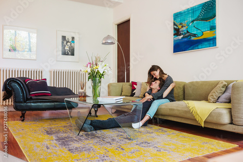 Young beautiful couple sitiing on a sofa, hugging each other