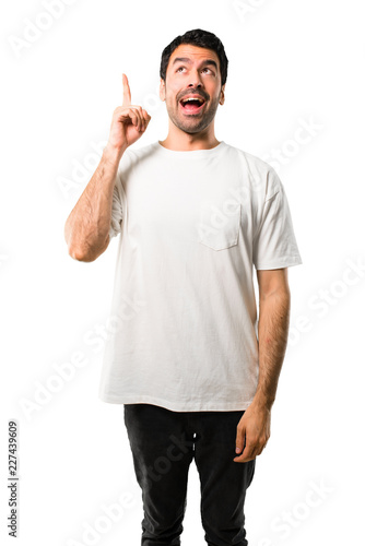Young man with white shirt intending to realizes the solution while lifting a finger up on isolated white background