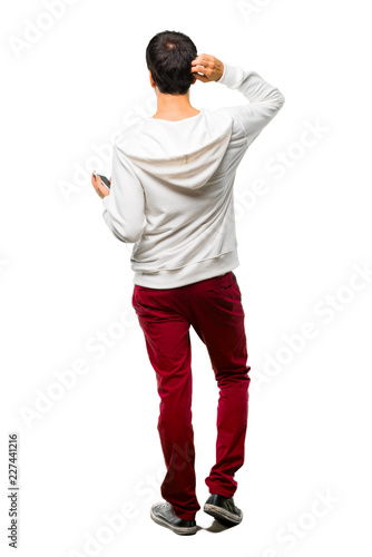 Full body of Man with glasses and listening music on back position looking back while scratching head on white background