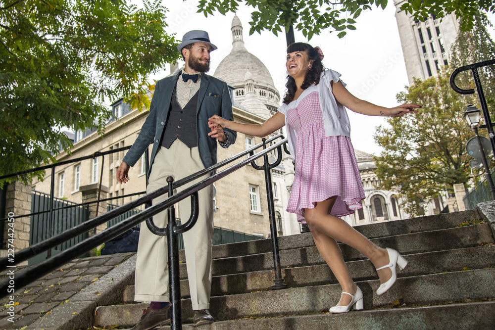 A couple of lovers dressed retro style walking down the stairs of a street of Montmartre, Paris, France A couple of lovers dressed retro style walking down the stairs of a street of Montmartre, Paris, France