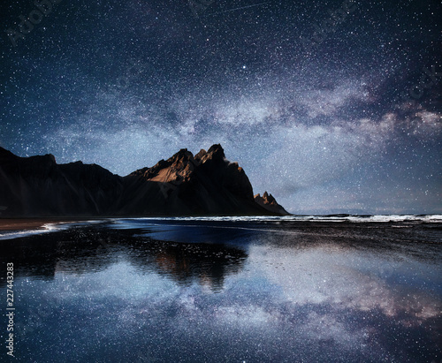 Amazing mountains reflected in the water at starry night. Stoksnes, Iceland