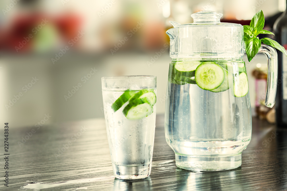 Pitcher with glass of cucumber water Pitcher with glass of cucumber water