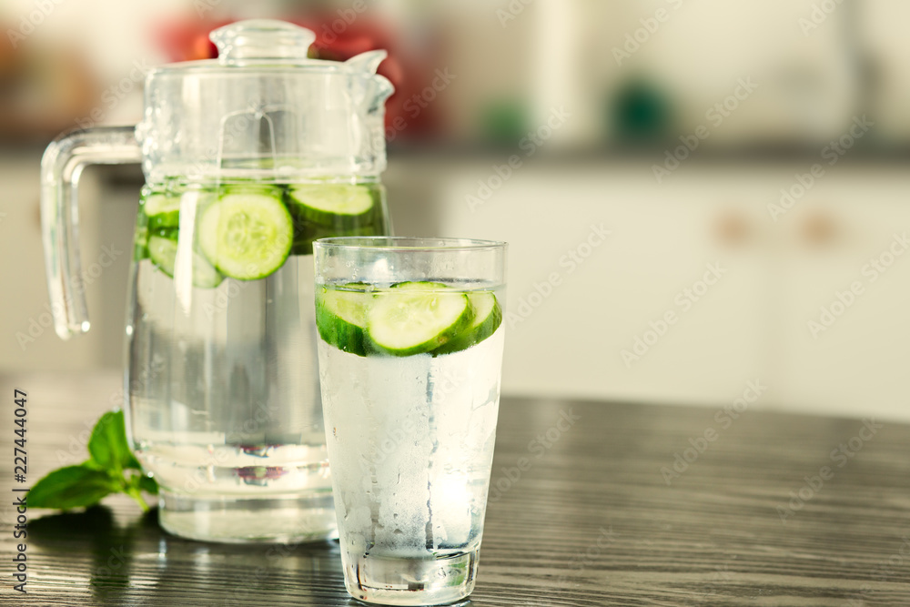 Pitcher with glass of cucumber water Pitcher with glass of cucumber water