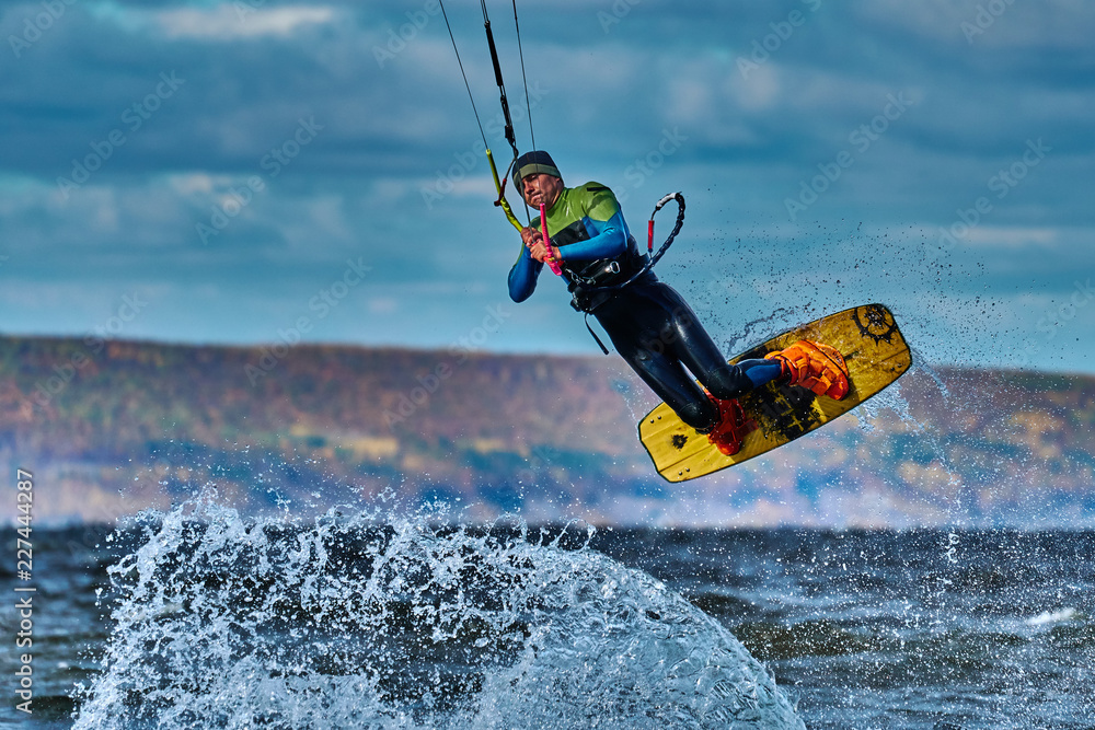 Naklejka premium A male kiter jumps over a large lake. Close-up.