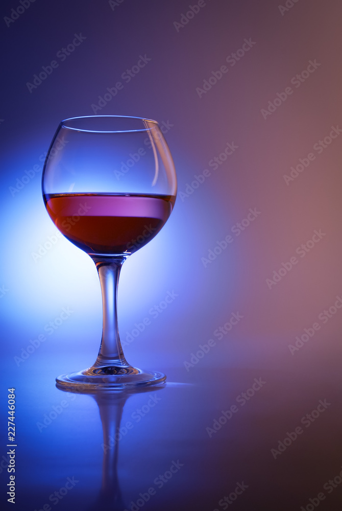 Glass of wine in abstract blue light Glass of wine in abstract blue light