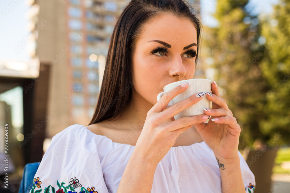 Beautiful young woman holding white cup outdoors Beautiful young woman holding white cup outdoors