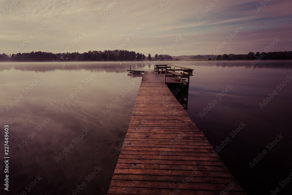 Wooden jetty on the lake at night, long exposure shot