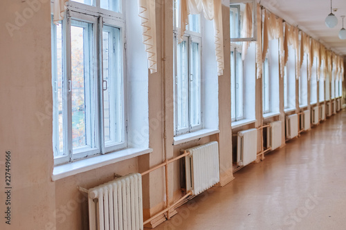 Vintage corridor inside the school building. With cast iron batteries and wooden window frames