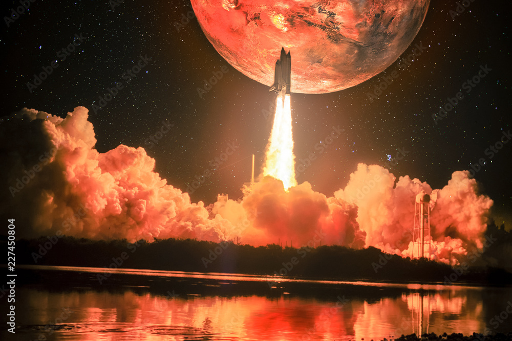 Fototapeta premium Rozświetlając nocne niebo, a także pobliską wodę, statek kosmiczny wlatuje w misję na Marsie. Ogromny czerwony Mars znajduje się na nocnym niebie otaczającym galaktykę. Elementy tego zdjęcia dostarczone przez NASA.