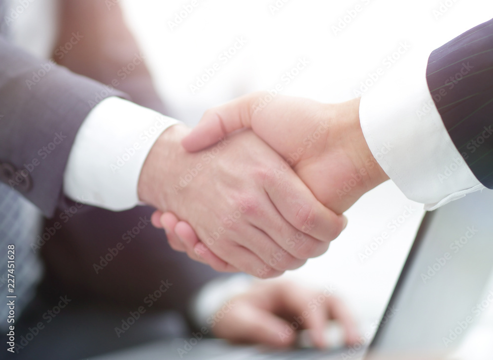 Closeup of business people shaking hands over a deal Closeup of business people shaking hands over a deal
