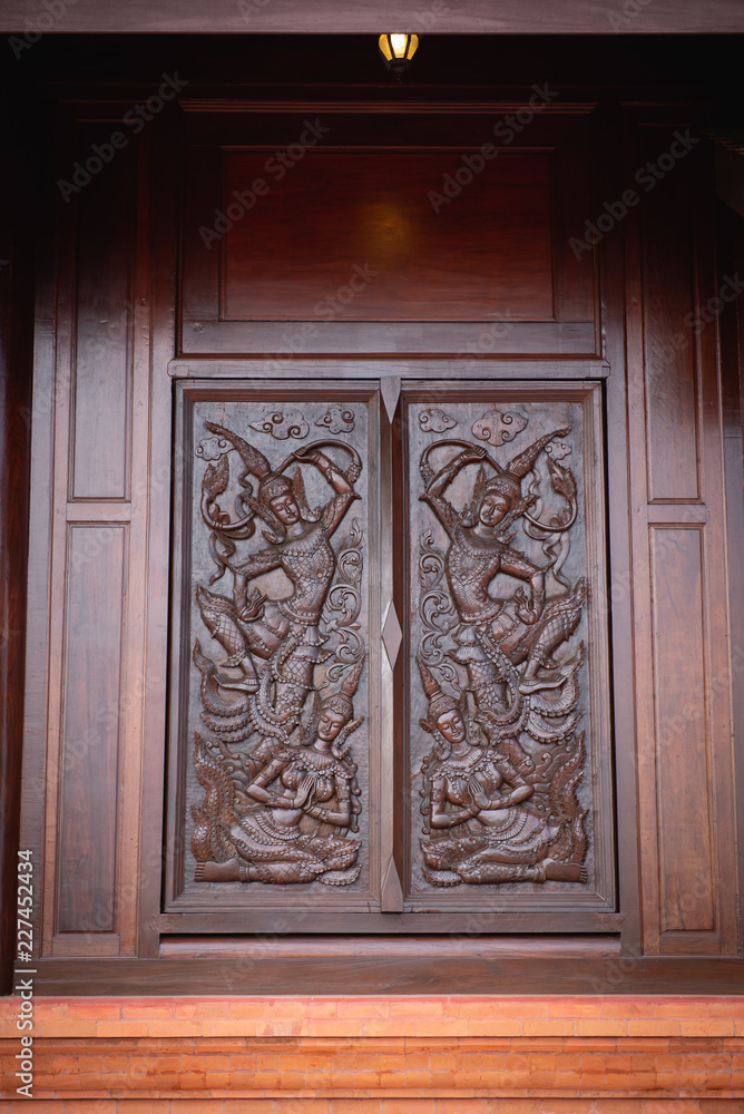 wood carving on the wall of temple in Thailand.