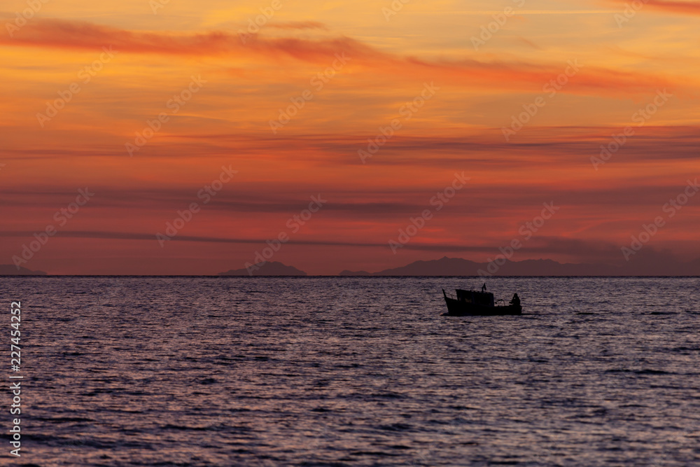 Fishing boat come back from fishing at sunset, Italy