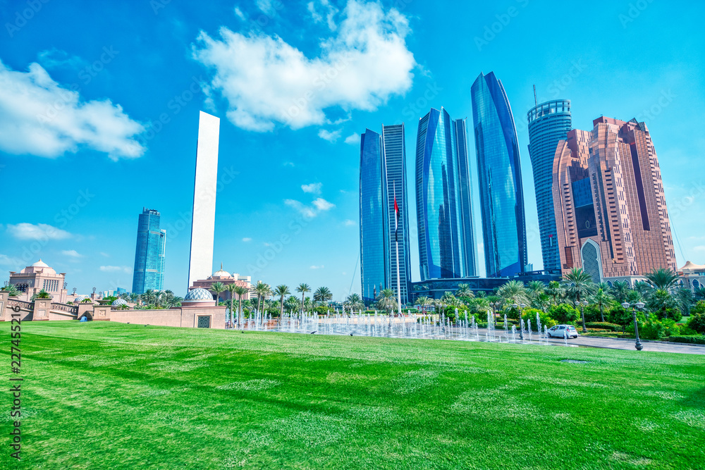 Abu Dhabi modern skyline from Emirates Palace Gardens on a sunny day