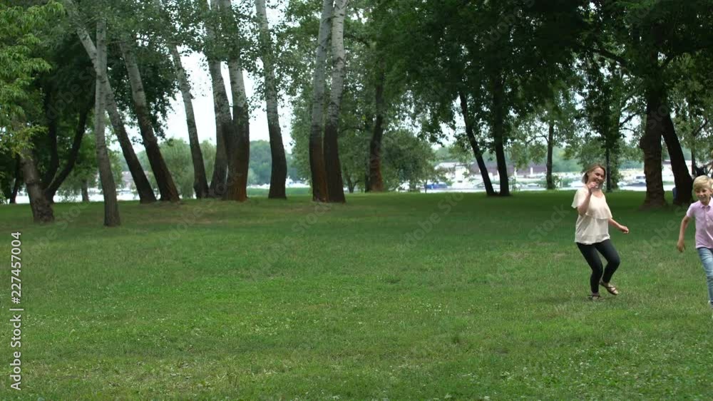 Mom and son playing catch-up in park, appreciate time together, happy childhood Mom and son playing catch-up in park, appreciate time together, happy childhood