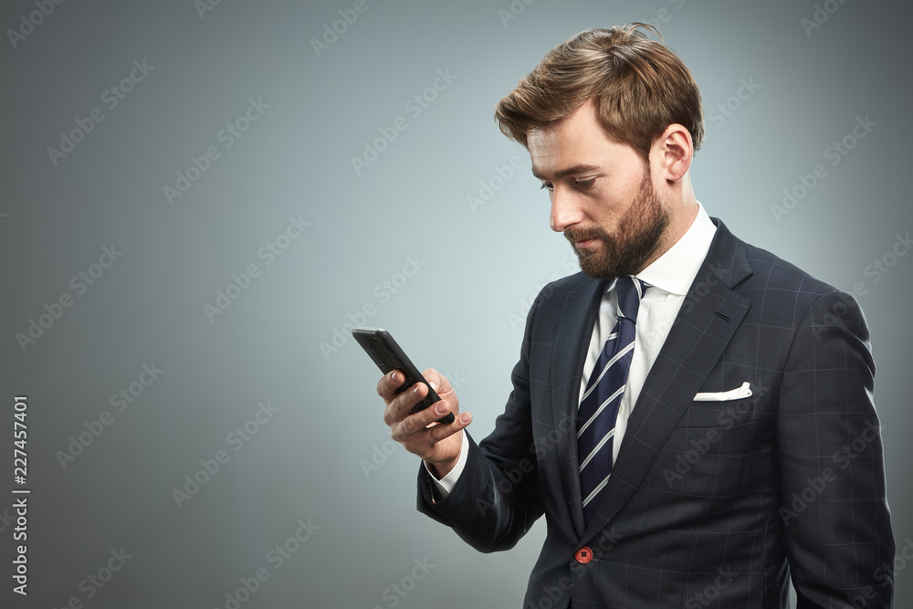 A man in a business suit with a smartphone. A man in a business suit with a smartphone.