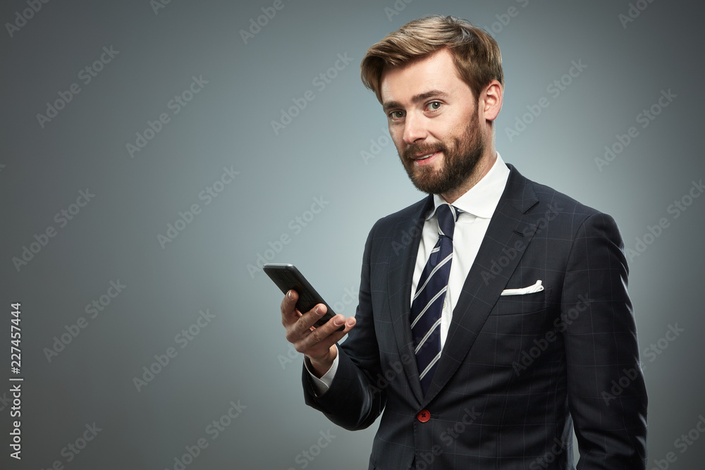 A man in a business suit with a smartphone. A man in a business suit with a smartphone.