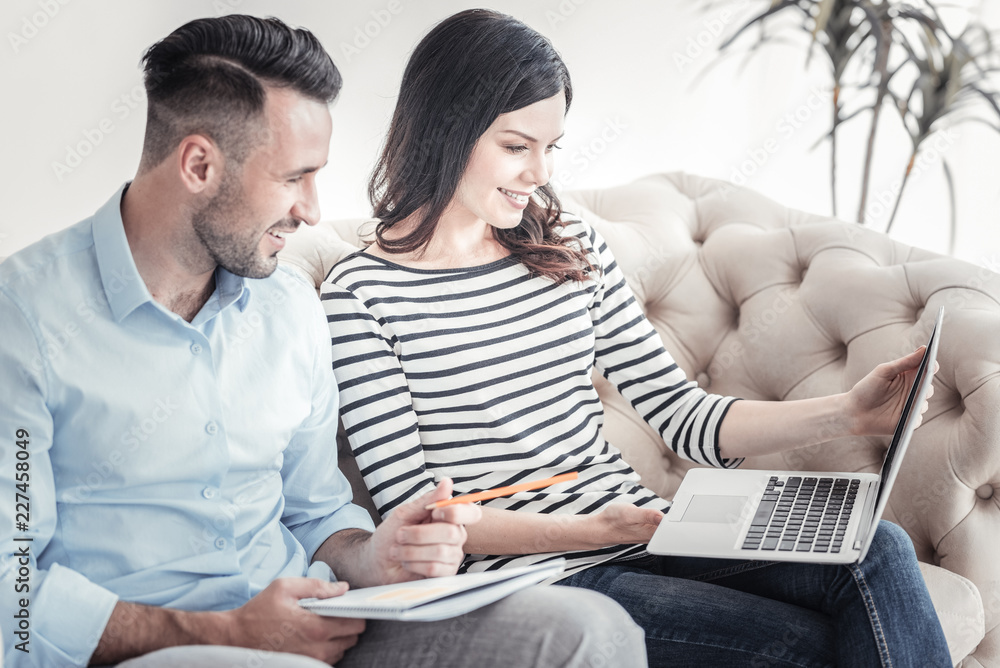 Be positive. Cheerful brunette girl expressing positivity while looking at screen of her laptop and spending time with pleasure Be positive. Cheerful brunette girl expressing positivity while looking at screen of her laptop and spending time with pleasure