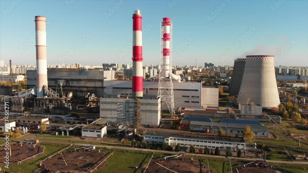 Aerial view of the Industrial Plant with Smoking Pipes near the City. Industrial zone. View from the drone to the factory. Aerial view of the Industrial Plant with Smoking Pipes near the City. Industrial zone. View from the drone to the factory.