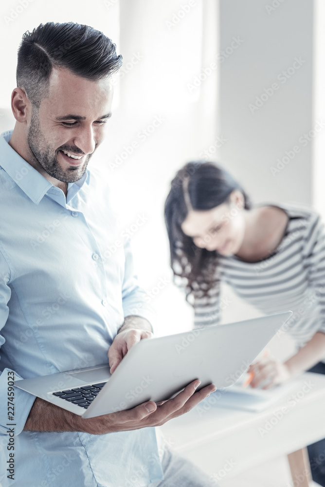 It is pause. Joyful man expressing positivity while having break, leaning on table It is pause. Joyful man expressing positivity while having break, leaning on table