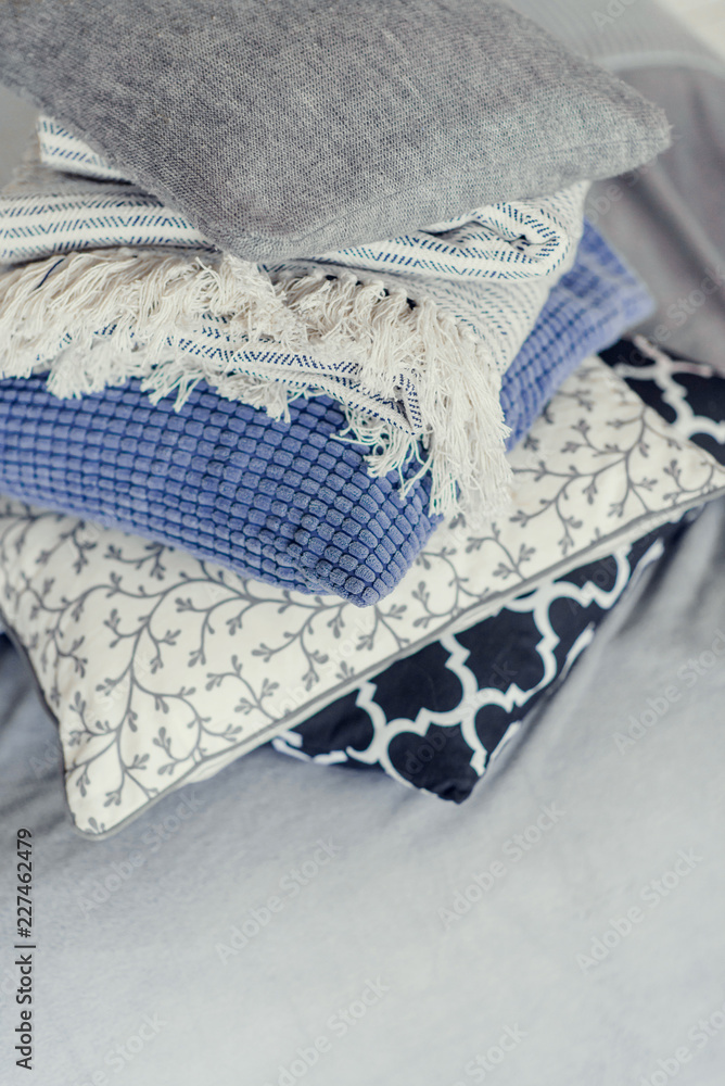 pile of pillows on the edge of the bed, in gray, monochrome pile of pillows on the edge of the bed, in gray, monochrome