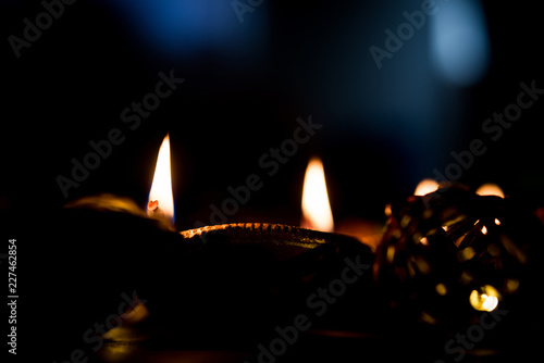 Beautiful diwali diyas at night with flowers, lighting series and gifts, moody background