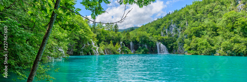 PLITVICE NATIONAL PARK, CROATIA - JUNE 8, 2018: Tourist group by the lake in the Plitvice Lakes National Park. photo