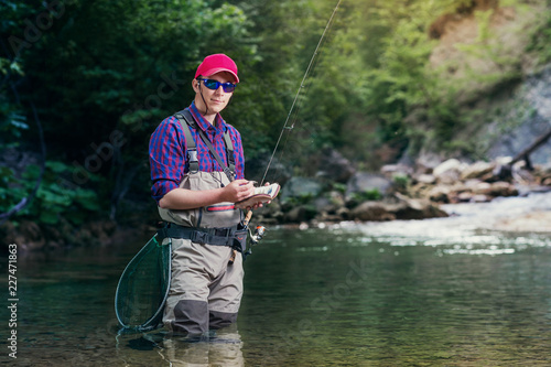 Εκτύπωση καμβά A fisherman chooses bait for trout fishing in the river
