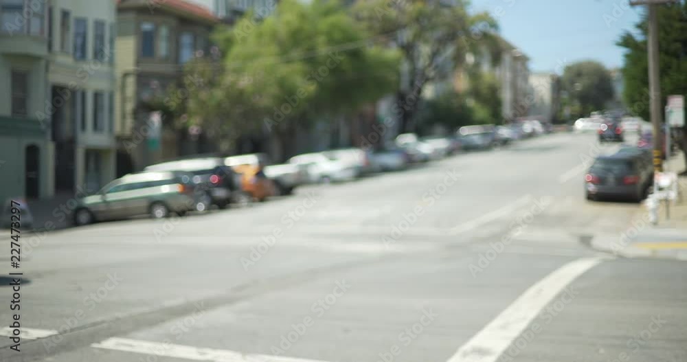 Exterior scene of cars driving uphill in San Francisco suburb with apartments Exterior scene of cars driving uphill in San Francisco suburb with apartments
