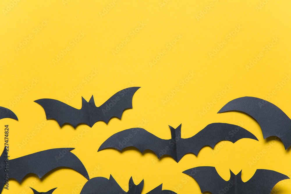 Naklejka premium Halloween paper vampire bat decorations on an orange background.