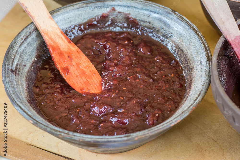 Homemade jam in clay bowl with wooden spoon Homemade jam in clay bowl with wooden spoon