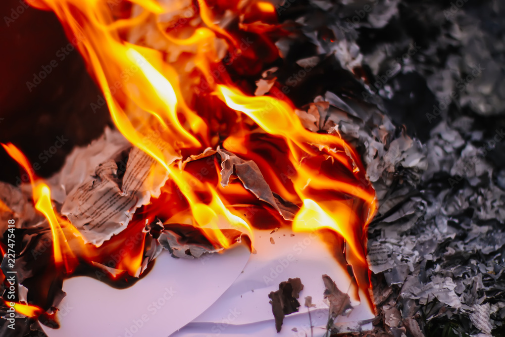 Paper burning on green summer grass outdoors. Paper burning on green summer grass outdoors.