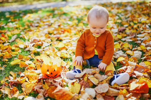 Cute little baby girl having fun on beautiful fall day