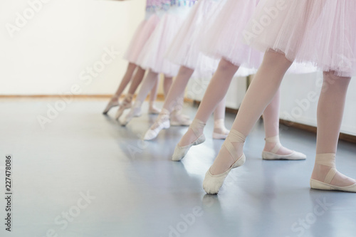 Ballerinas in pointe shoes stretching legs before dance lessons