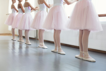 Acrylglasbilder Tanzschule Ballerinas an der Stange Grundposition  © Prostock-studio