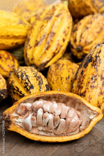 Cocoa beans and cocoa pod on a wooden surface.