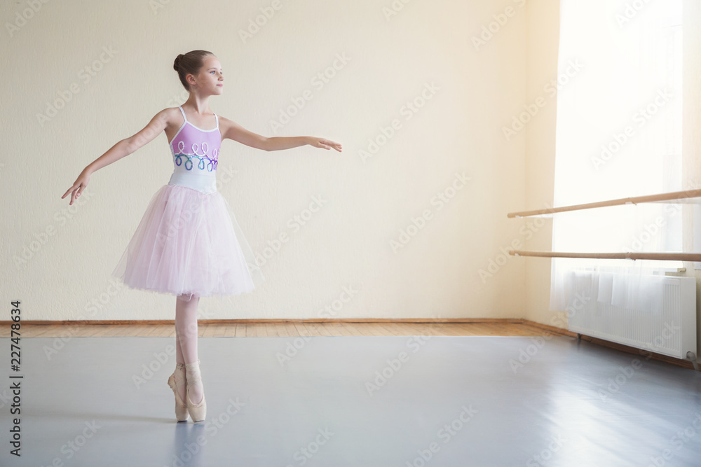 Graceful ballerina practicing ballet positions in light class Graceful ballerina practicing ballet positions in light class