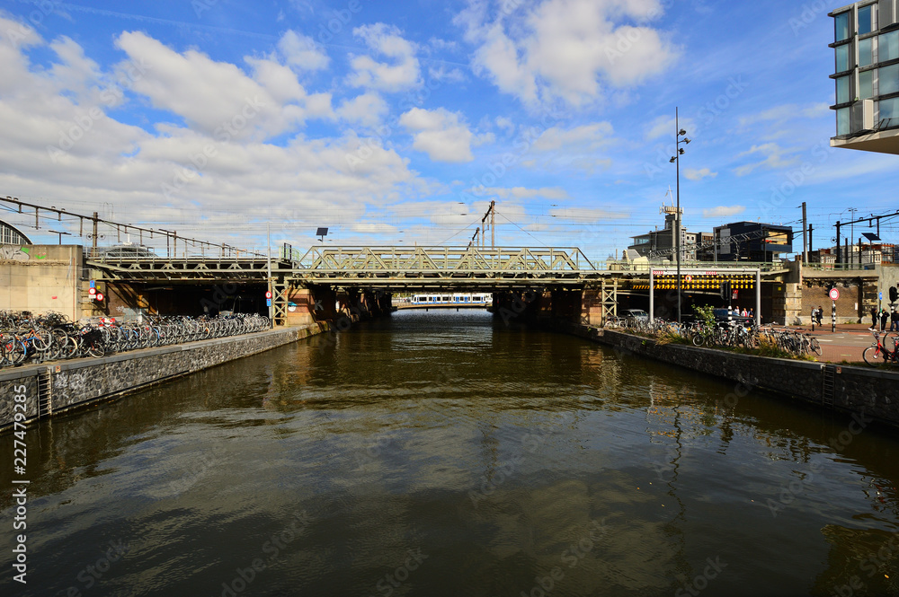 Most kolejowy nad rzeką w słoneczny dzień.