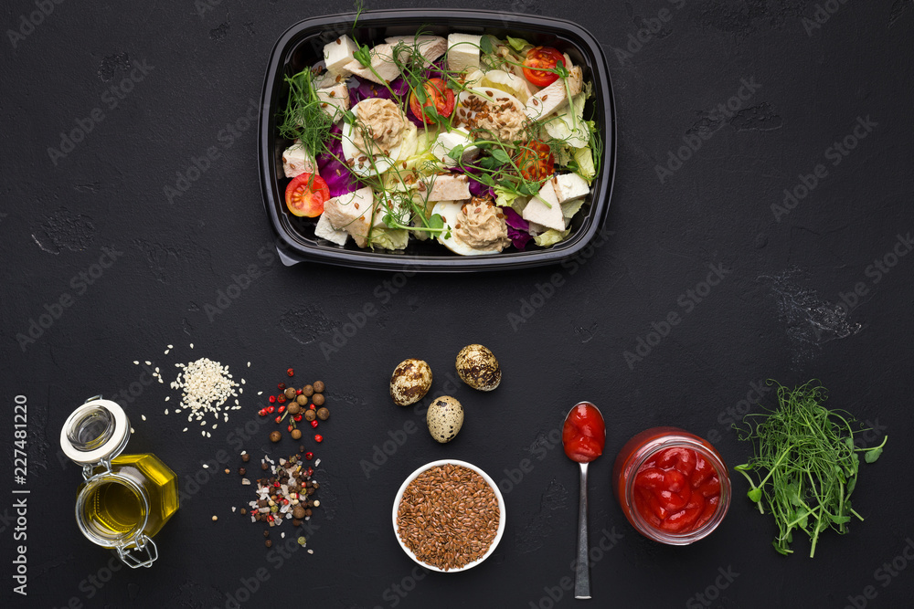 Salad with sauces and spices on black background