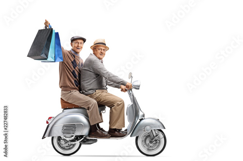 Two elderly men on a vintage scooter with shopping bags