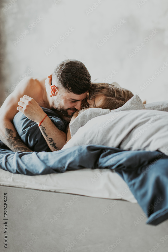 
beautiful loving couple kissing in bed